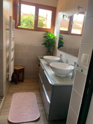 Un baño con dos lavabos y un espejo. en Chez vero, en Le Boulou