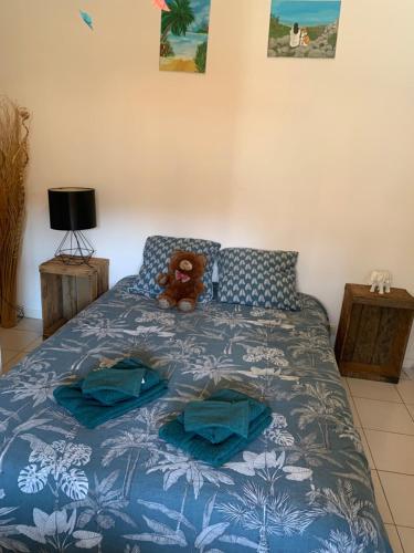 Un osito de peluche sentado en una cama en un dormitorio. en Chez vero, en Le Boulou