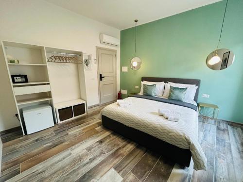 a bedroom with a bed and a green wall at WelcHome Vitorchiano in Vitorchiano