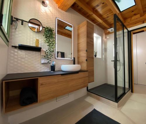 une salle de bain avec un lavabo et un miroir dans l'établissement Maison Gruissan village, à Gruissan