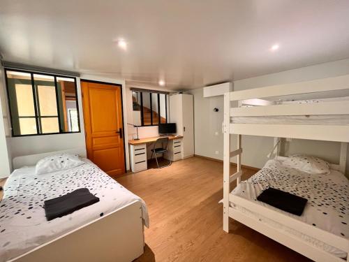 une chambre avec deux lits superposés et un bureau dans l'établissement Maison Gruissan village, à Gruissan