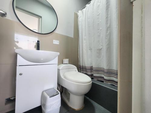 a bathroom with a toilet and a sink and a mirror at Hotel Villa del Sol in Piura