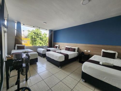 a hotel room with three beds and a camera at Hotel Villa del Sol in Piura
