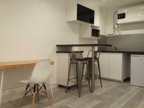 une cuisine avec une table et des chaises dans une pièce dans l'établissement Studio Peyrou Arceaux, à Montpellier