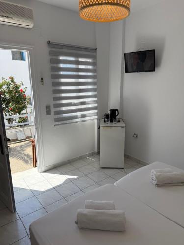 a white bedroom with a bed and a window at Chrysa House in Kamarai