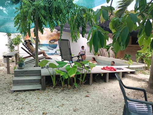 a group of people sitting on a picnic table in front of a painting at Hostel Ximbal in Bacalar