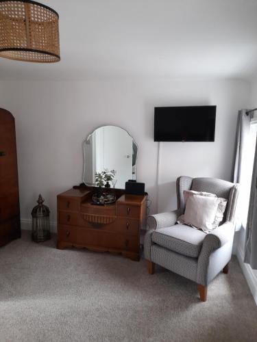 a living room with a chair and a mirror at Ironbridge town apartment in Ironbridge