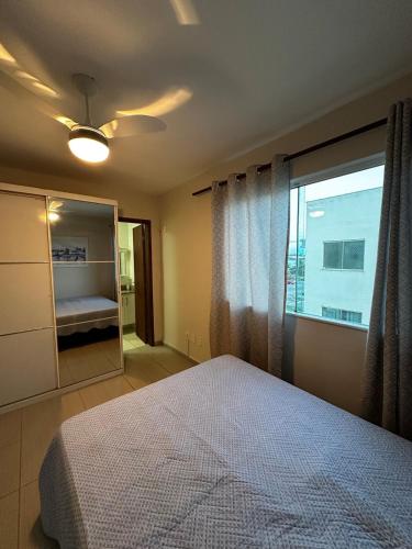 a bedroom with a bed and a large window at Apartamendo Marina Clube in São Pedro da Aldeia