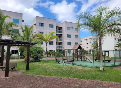 un parque infantil frente a un gran edificio en Apartamendo Marina Clube, en São Pedro da Aldeia