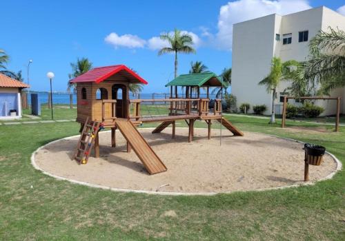 Un patio de juegos con dos equipos de juego en un parque. en Apartamendo Marina Clube, en São Pedro da Aldeia
