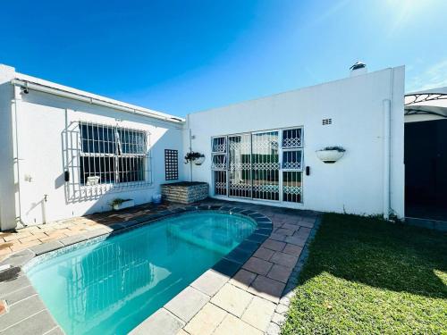 a swimming pool in front of a white house at Casa Da Gama Luxe in Marina Da Gama