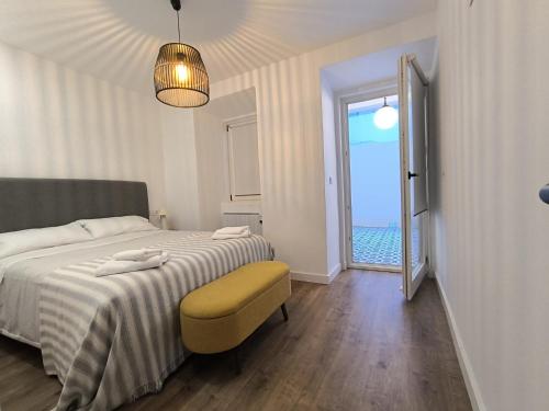 a bedroom with a bed and a chair and a window at La real 2 céntrico con terraza in Ferrol