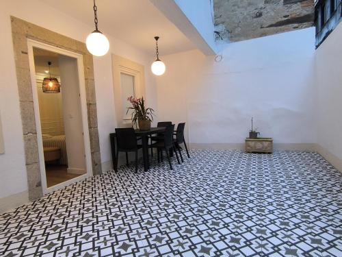 a dining room with a table and chairs on a tiled floor at La real 2 céntrico con terraza in Ferrol
