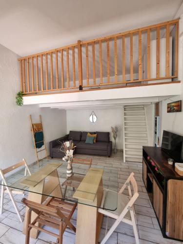 un salon avec un canapé et une table en verre dans l'établissement Loft studio avec mezzanine, limitrophe Monaco, à Roquebrune-Cap-Martin