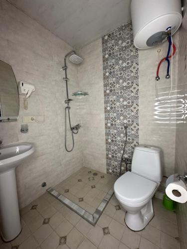 a bathroom with a toilet and a shower and a sink at Aqua Batumi 46 in Batumi