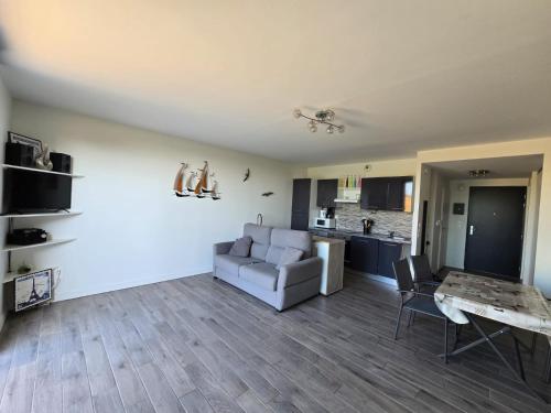 un salon avec un canapé et une table dans l'établissement Appartement Lavoisier, à La Rochelle