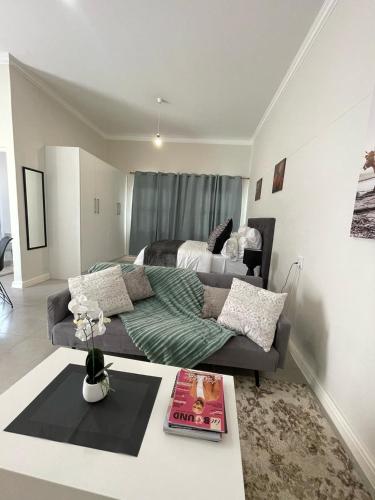 a living room with a couch and a bed at Sunningdale White House Accomodations in Cape Town