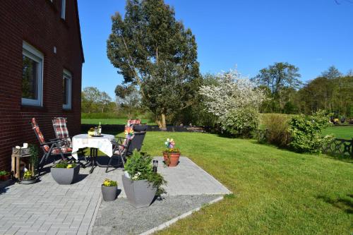 a patio with a table and chairs in a yard at Haus Bootsmann Süd in Wüstenei Mooräcker