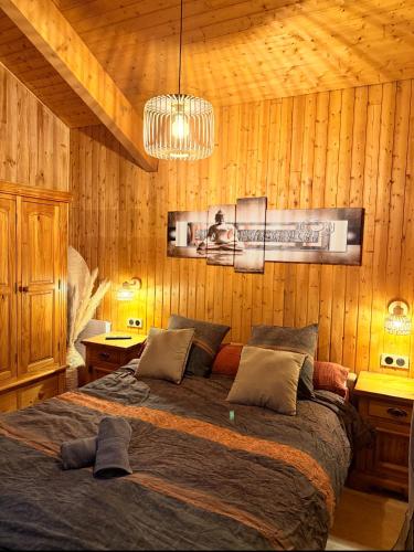 a bedroom with a large bed in a wooden wall at Chalet Des Charmes in Thollon