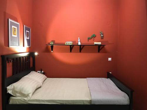 a bedroom with a bed and a red wall at never on monday studio-apARTment in Rethymno Town
