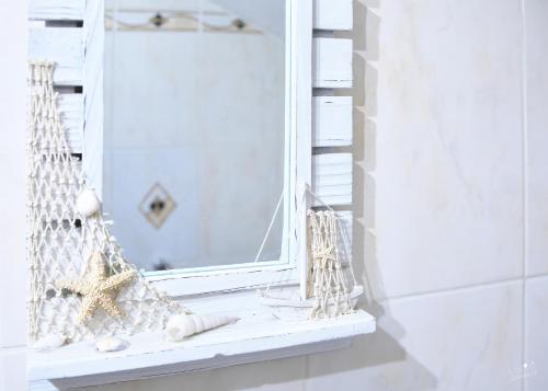 a window with seashells and a mirror in a bathroom at Familienappartement Seppenbauer in Bad Ischl