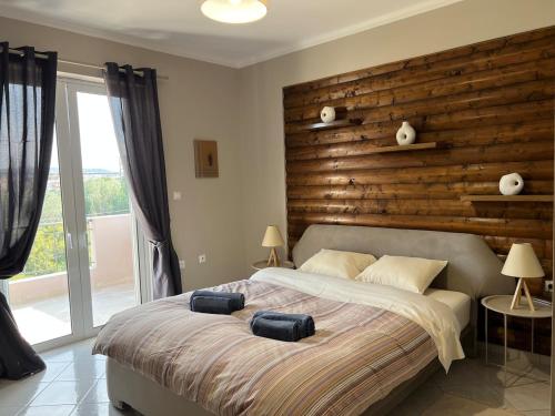 a bedroom with a large bed with two bags on it at Lithos Apartment in Artemida