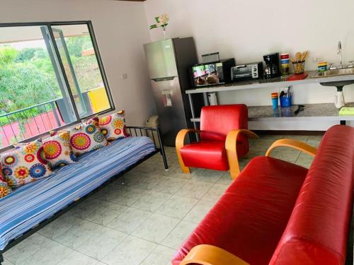salon z kanapą i czerwonym krzesłem w obiekcie Monkey View w mieście Puerto Viejo