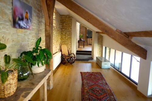 a large living room with a stone wall at Au Petit Bercail - Le Loft - Gite pour 4 personnes in Chiny