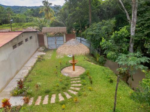 a small garden with a grass umbrella in the yard at Amasisa Casa Vacacional Sauce, Laguna Azul in Sauce