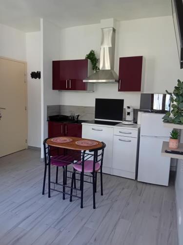 une cuisine avec une table et des chaises dans une pièce dans l'établissement Studio centre-ville, à Uzès