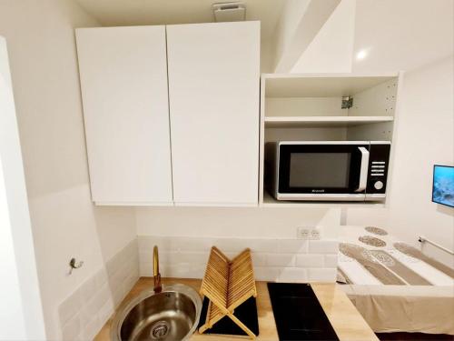 une cuisine avec un évier et un micro-ondes dans l'établissement Le Marty 2 Studio, à Carcassonne