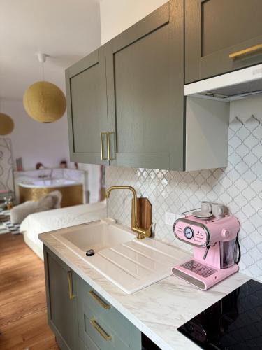 une cuisine avec un appareil électroménager rose Hello Kitty sur un comptoir dans l'établissement Mini loft Spa - Cosy, à Dijon