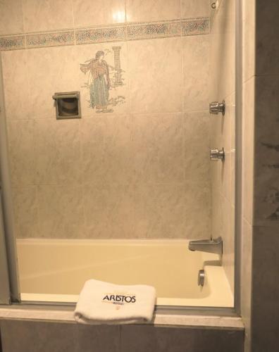 a bathroom with a shower with a towel on the tub at Hotel Aristos Acapulco in Acapulco