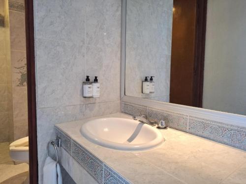 a bathroom with a sink and a mirror at Hotel Aristos Acapulco in Acapulco