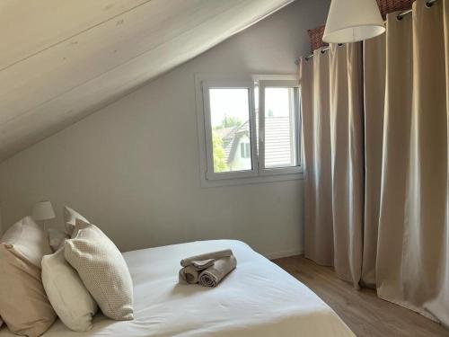 a white bed with a pair of shoes on it at Vacances alliant confort et quiétude en pleine nature ! in Echallens