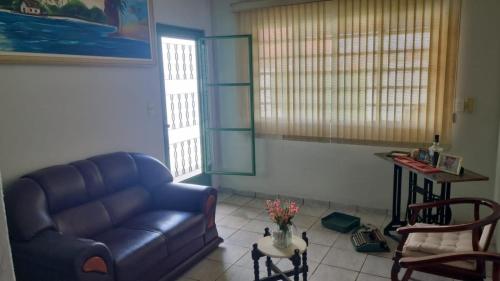 a living room with a blue couch and a table at Casa familiar in Passos