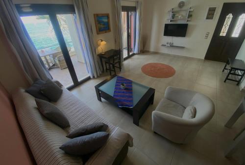 a living room with a couch and a chair and a table at Anemos-Halcyon-Eirene in Mochlos