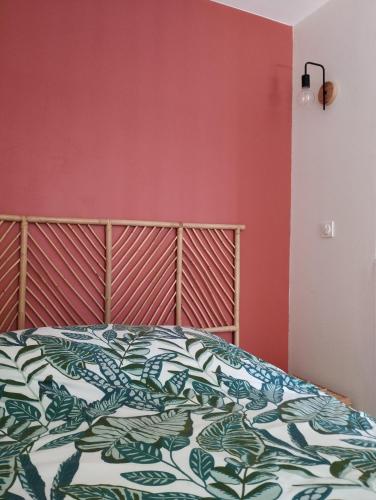 une chambre avec un lit et un mur rouge dans l'établissement Studio climatisé et spacieux situé près des Parcs, à Vichy