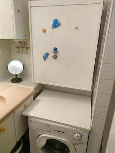 une petite salle de bains avec un lave-linge. dans l'établissement Abri Côtier, au Cap d'Agde