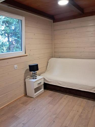 a small bedroom with a bed and a window at Domek wakacyjny in Sumowo