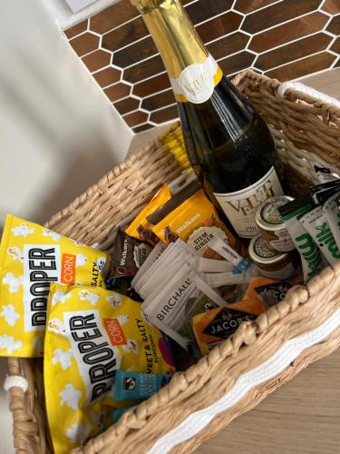 a basket with a bottle of wine and chips at The Fireman's Bungalow in Springwell