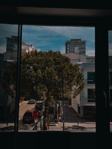 a window view of a street with a tree and buildings at El Mare Hotel and Restaurant in Durrës