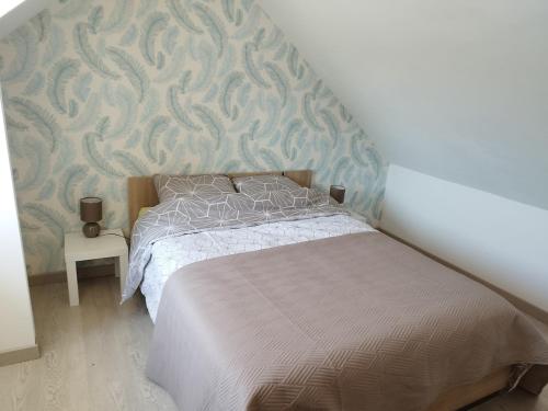 a bedroom with a bed and a wall at Petite Maison a deux pas du centre in Le Faou