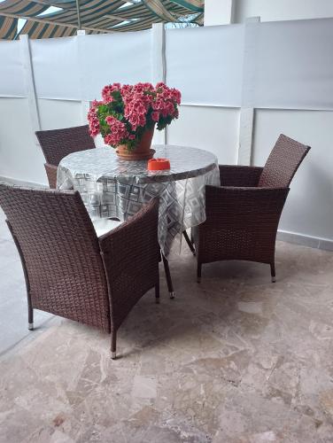 a table and chairs with a vase of flowers on it at casa al mare kalispera in Marina di Mancaversa