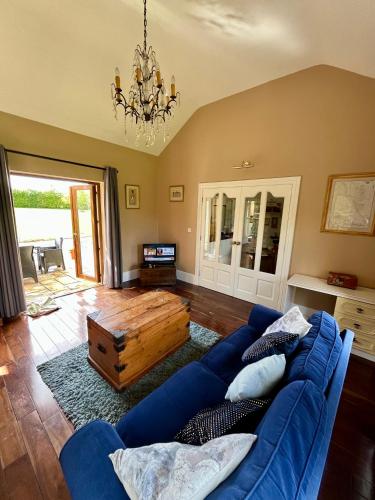 a living room with a blue couch and a table at Countryside House & private garden in Limerick