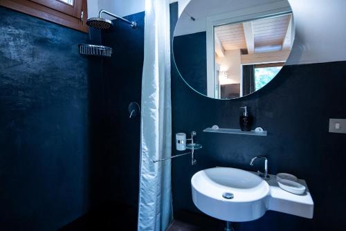 a blue bathroom with a sink and a mirror at Exclusive Villa in Porto Rotondo with jacuzzipool in Porto Rotondo