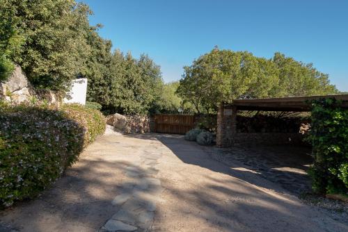 a pathway in a yard with a fence and trees at Exclusive Villa in Porto Rotondo with jacuzzipool in Porto Rotondo