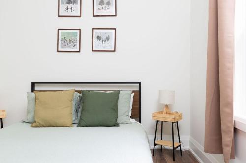 une chambre avec un lit avec quatre tableaux au mur dans l'établissement All Season Muskoka Cottage, à Huntsville