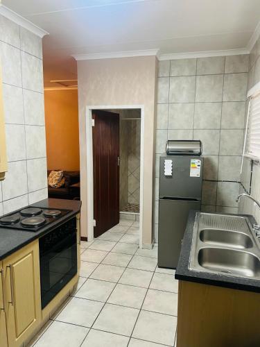 a kitchen with a sink and a refrigerator in it at 9 on Deimos Ave in Polokwane