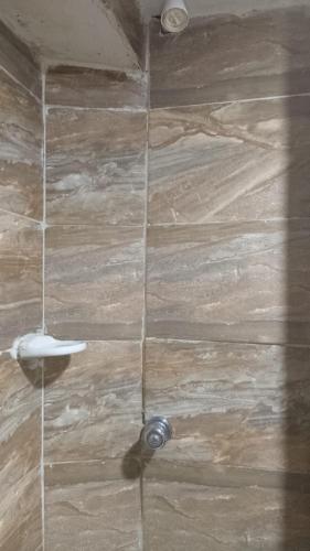 a shower with a stone wall with a shower nozzle at Hostal #10-33 in Cartagena de Indias